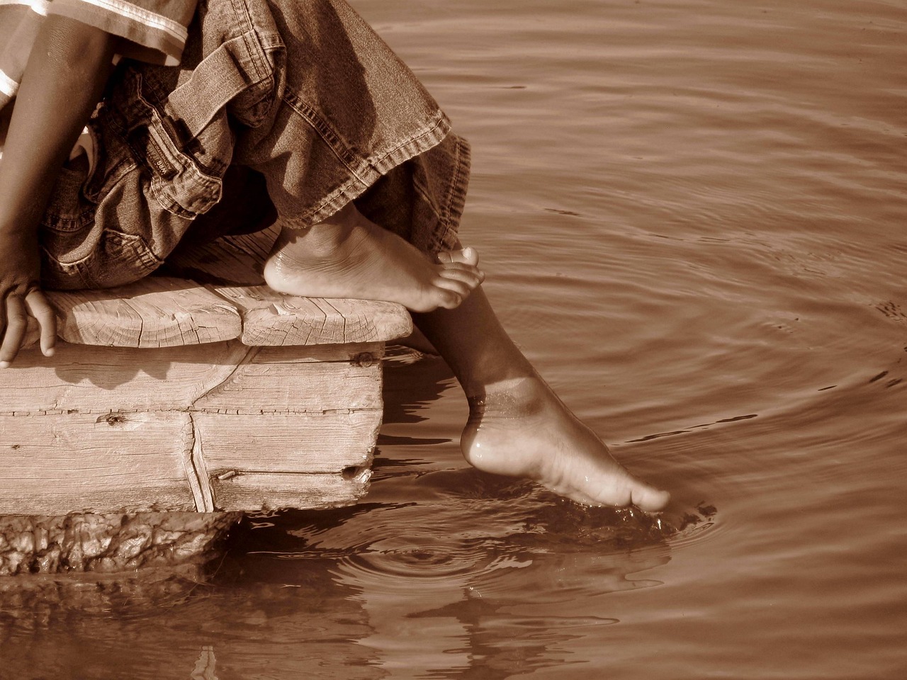 Child dipping toe in water